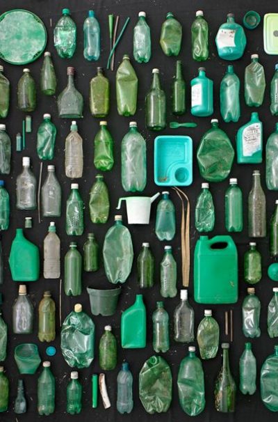green plastic and glass containers on black background